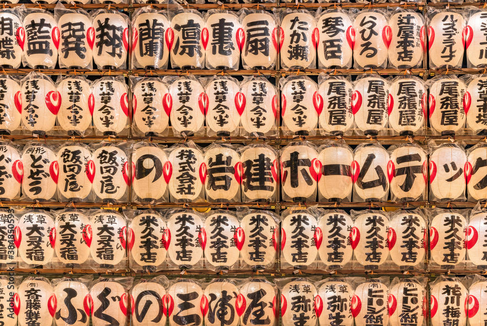 Close-up of a huge wall of luminous japanese paper lanterns decorated with the handwritten names of patrons and sponsors of the Tori-no-Ichi Fair of Ootori shrine.
