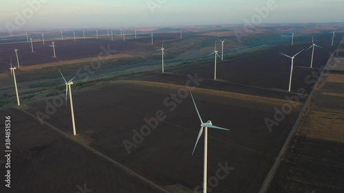 Eolian turbines park at sunet, warm light. Wind power concept
