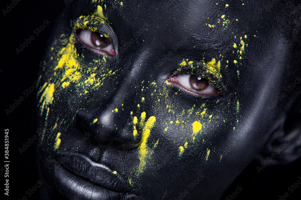 Yellow and black body paint. Woman with face art. Young girl with