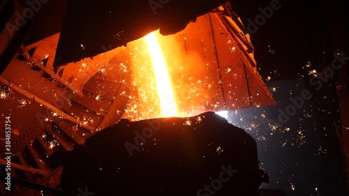 A stream of molten metal is poured into the ladle.