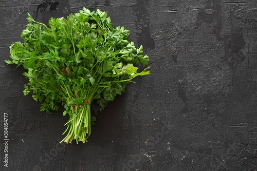 Fresh parsley bunch on black background, top view
