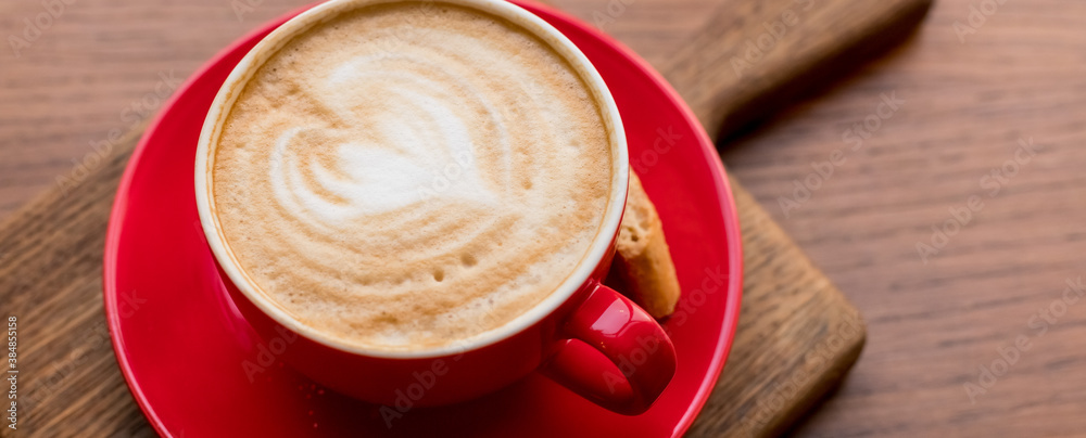 Latte Art,Side view of hot coffee isolated on wooden background.Morning with a red cup of coffee or cappuccino. Art and craft coffee. web banner Latte Art,Side view of hot coffee isolated on wooden background.Morning with a red cup of coffee or cappuccino. Art and craft coffee. web banner