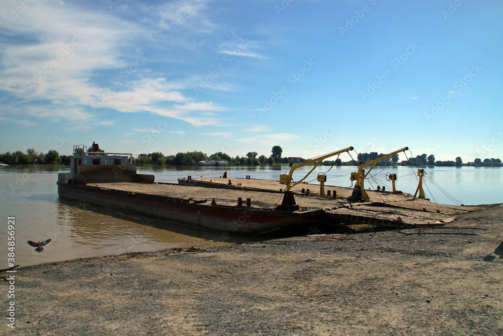 Una vieja barcaza en la orilla del río Danubio a la espera de ser cargada. Delta del río Danubio al amanecer cuando pasa cerca de Nufaru, Rumania.