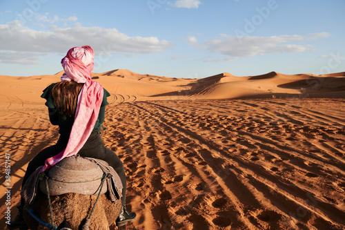 Tourist turban riding dromedary desert photo