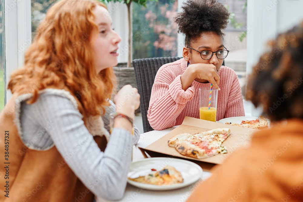 Teens talking over pizza and juice Teens talking over pizza and juice