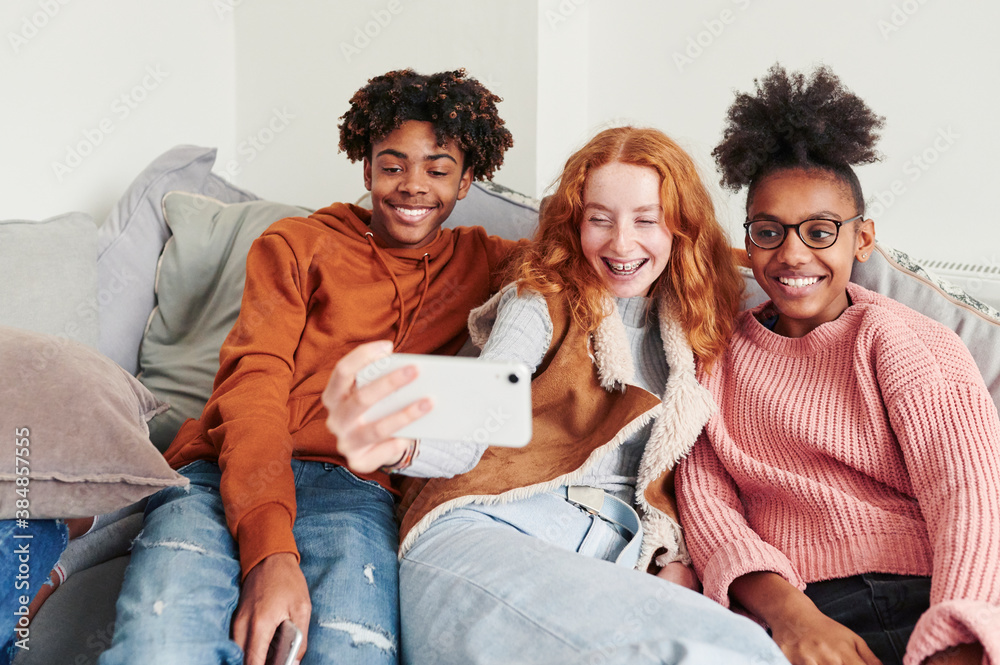 Teens taking selfies at home