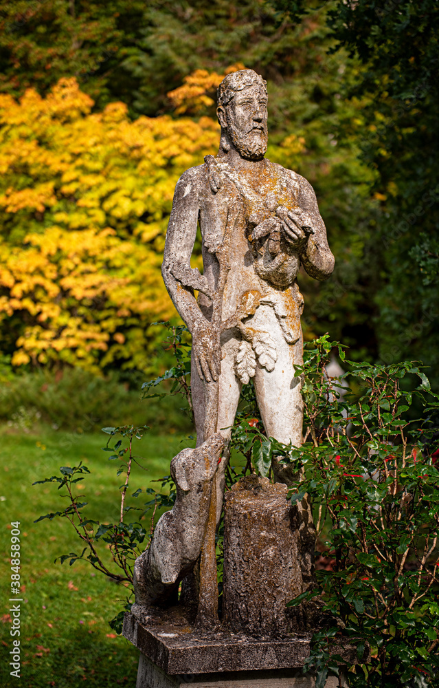 Stone statue of a shepherd with dog in the park Stone statue of a shepherd with dog in the park