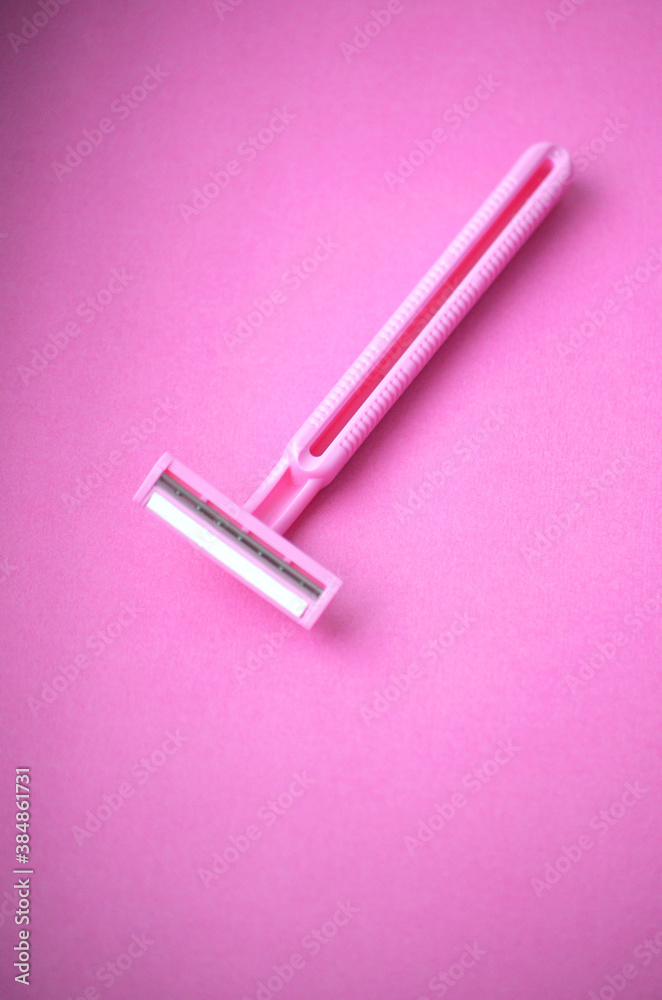 Isolated pink plastic female razor for single use on a same pink background. Copy space. Isolated pink plastic female razor for single use on a same pink background. Copy space.
