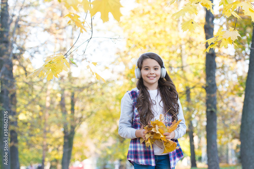 Totally happy. beauty and nature. happy kid wear headphones. teen girl listen music on the way to school. child walk in autumn forest. fall maple leaves in park. online education. childhood happiness