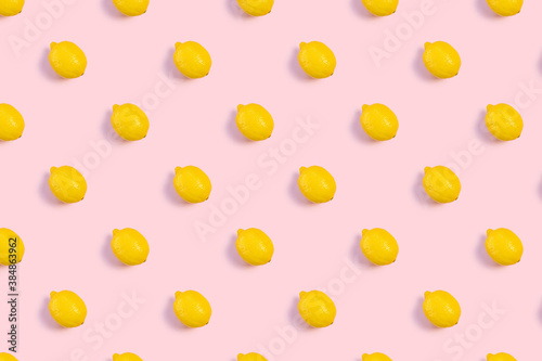 Bright pattern from fresh whole lemons on a pink background. Citrus, vitamin C, fruit.