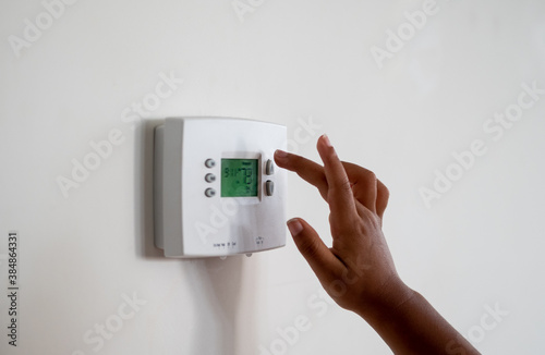 Girl touching a Thermostat photo