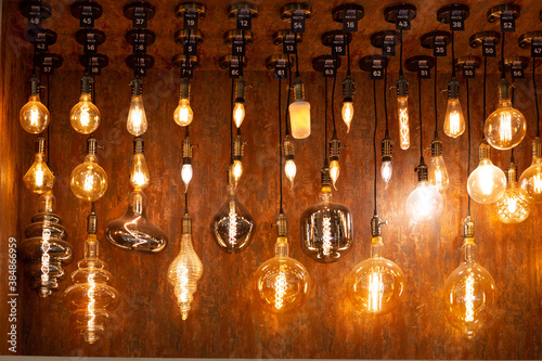 vintage glowing light bulbs on brown wall background, home and indoor decor.