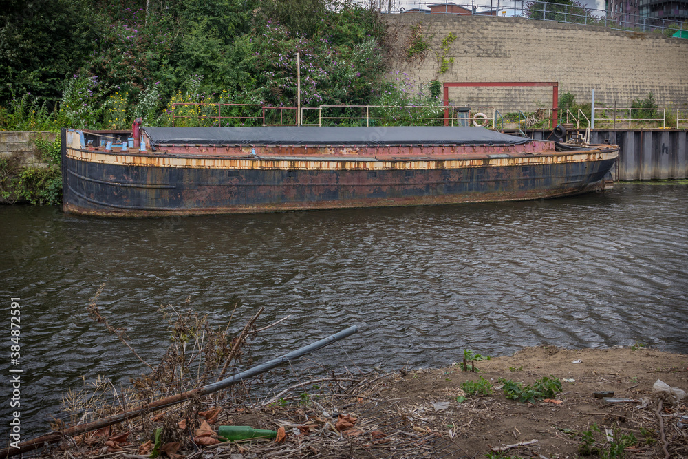 Old decrepit cargo boat on a canal
