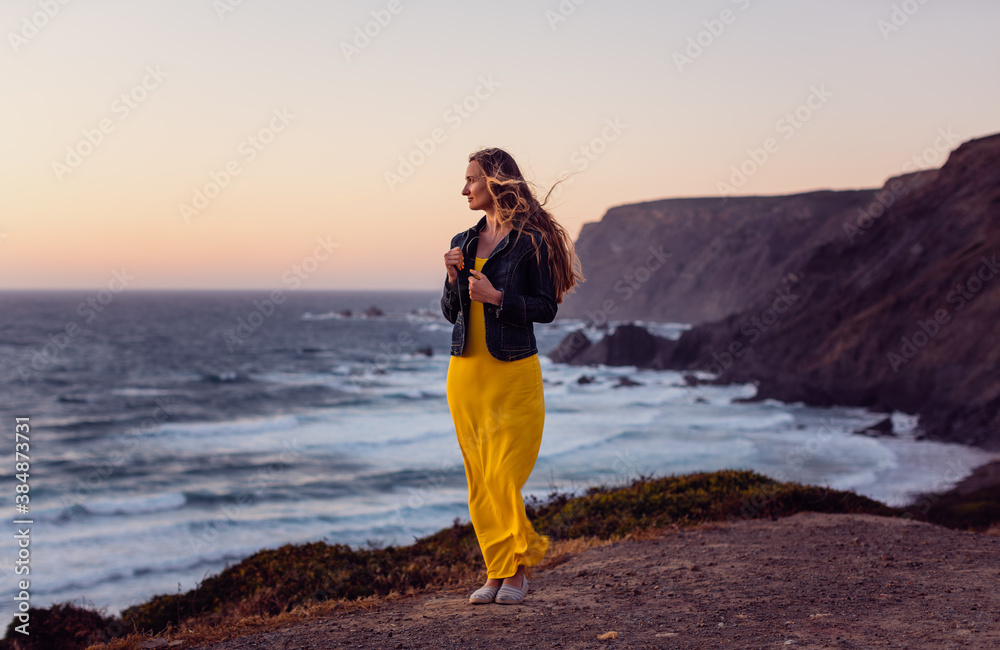 Woman on a sunset beach with the wind in her hair