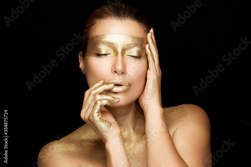 Beauty woman face with gold mask. Gold based skincare concept. Cosmetology and spa treatment