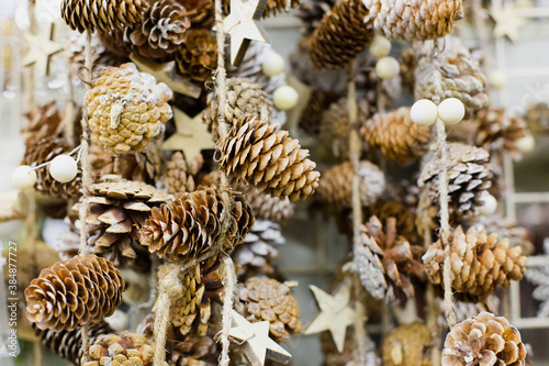 Fototapeta Naklejka Na Ścianę i Meble -  pine cones with snow weigh on the rope as a Christmas background. Close-up . Christmas baubles