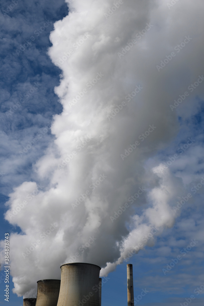 Cooling towers of a power plant with white clouds of steam - Stockphoto