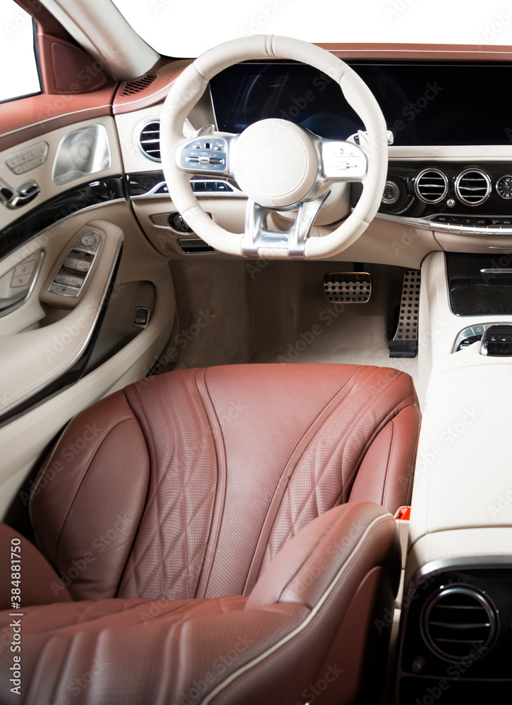 Modern luxury car Interior - steering wheel, shift lever and dashboard. Car interior luxury. Beige comfortable seats, steering wheel, dashboard, speedometer, display. Red and white perforated leather.