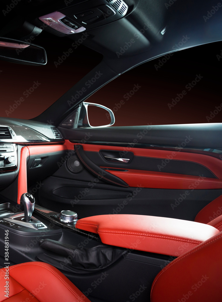 Modern luxury car Interior - steering wheel, shift lever and dashboard. Car interior luxury inside. Steering wheel, dashboard, speedometer, display. Red and black leather cockpit