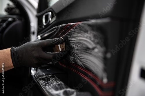 Obraz na płótnie Car detailing studio worker cleaning leather car interior upholster w salonie