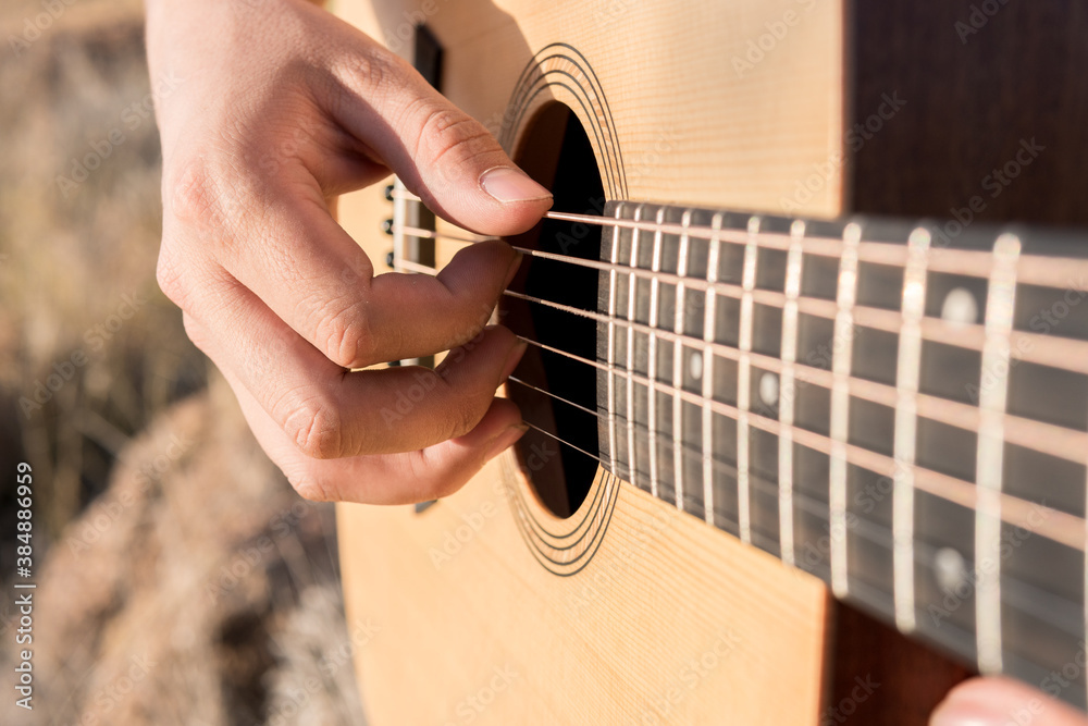Fototapeta premium Man's hands playing an acoustic guitar