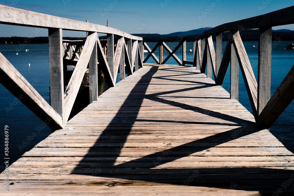 The morning sun paints geometrics patterns on a pier along the coast of Maine The morning sun paints geometrics patterns on a pier along the coast of Maine