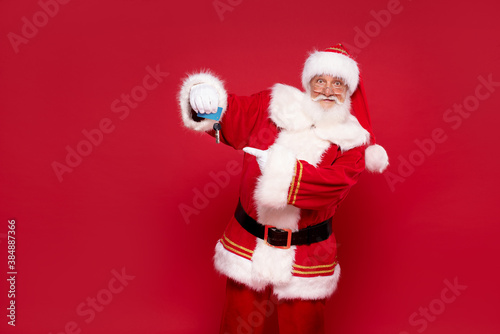 Happy Santa Claus with house keys as a gift. © neonshot
