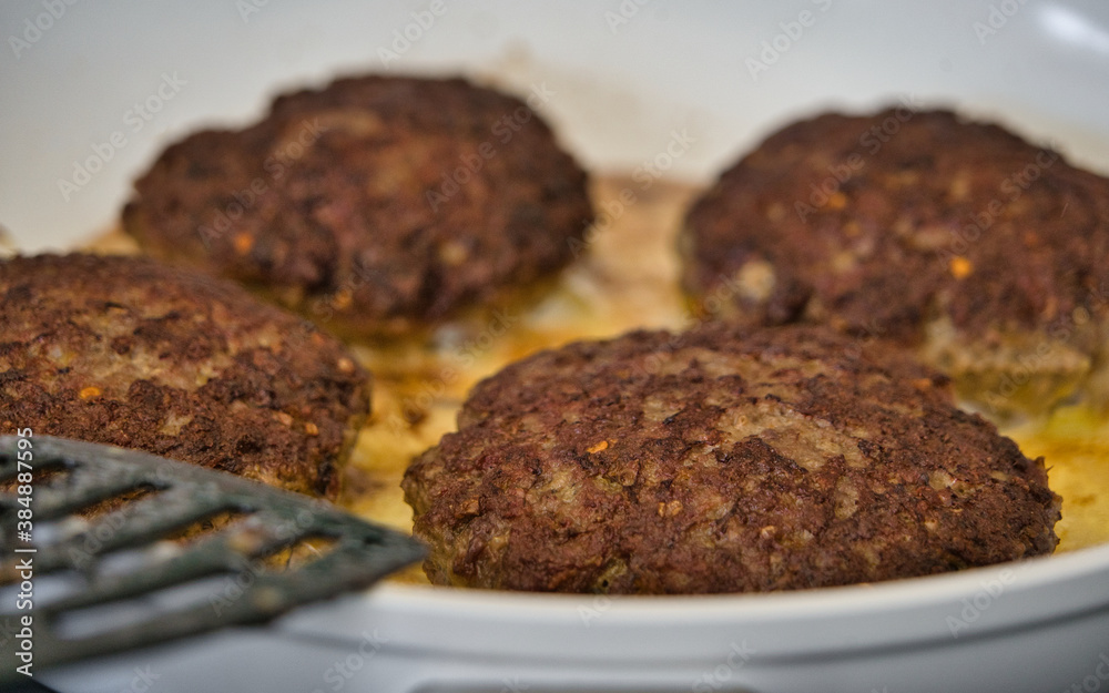 Frikadellen Gemüse Fleisch Paddys mit Kurkuma beim Anbraten in weißer Teflonpfanne mit Kokosöl, Produktbild Frikadellen Gemüse Fleisch Paddys mit Kurkuma beim Anbraten in weißer Teflonpfanne mit Kokosöl, Produktbild
