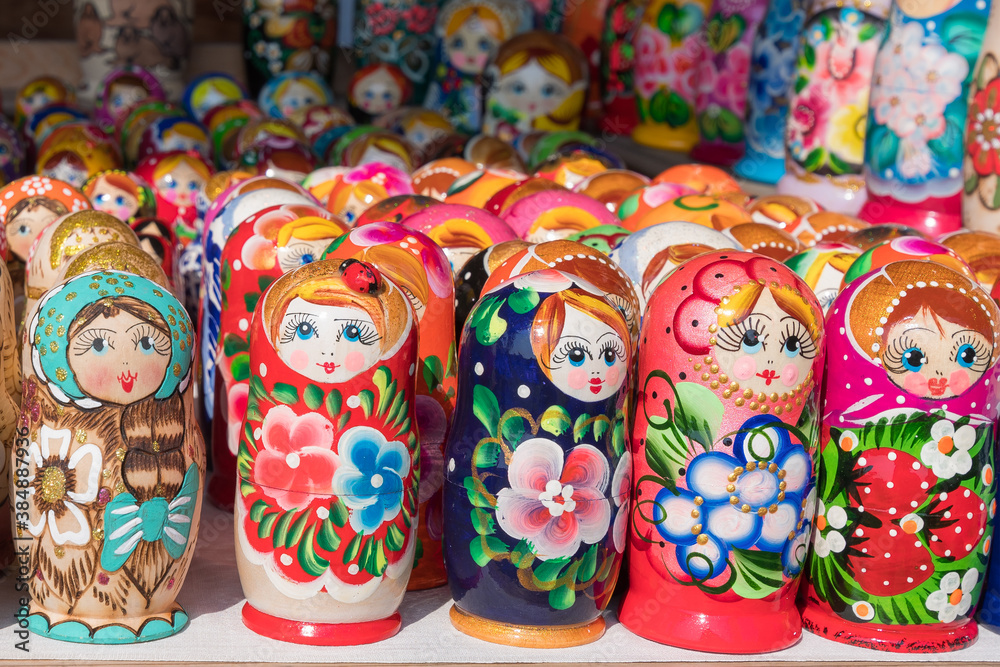 Traditional Russian folk crafts. Multicolored wooden nesting dolls stand on a street counter.