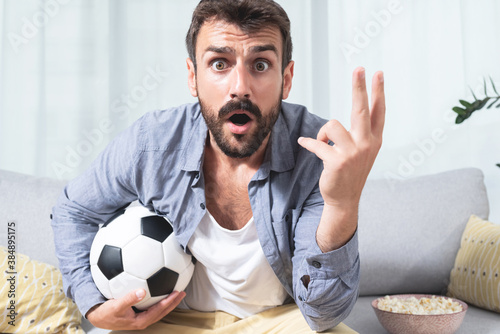 Фототапет Young man shocked while watching football match
