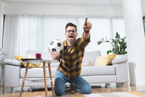 Football fan celebrating victory at home photo