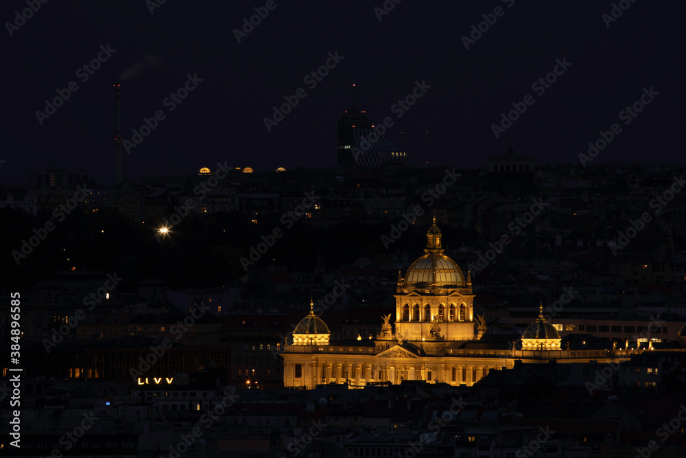 view of the roofs of buildings in the city of prague and the enlightened national museum from 1818 in the czech republic at night