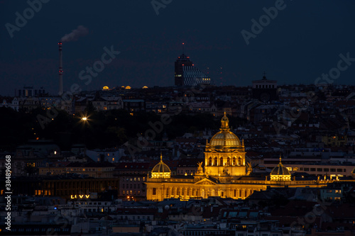 view of the roofs of buildings in the city of prague and the enlightened national museum from 1818 in the czech republic at night