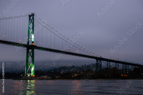 A view of the Lion's Gate Bridge connecting Vancouver to the North Shore through Stanley Park, over English Bay in British Columbia, at night.