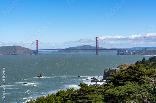 Distant View of Golden Gate Bridge with Ocean and Greenery.