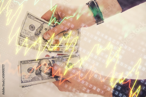 Multi exposure of financial graph drawing hologram and USA dollars bills and man hands. Analysis concept.