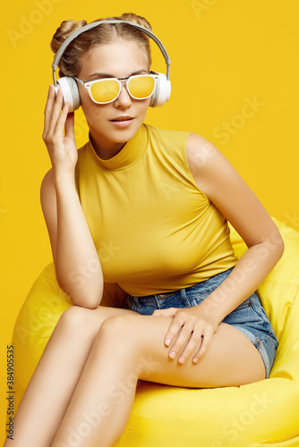 Gorgeous blonde hipster girl wearing sunglasses enjoys the music