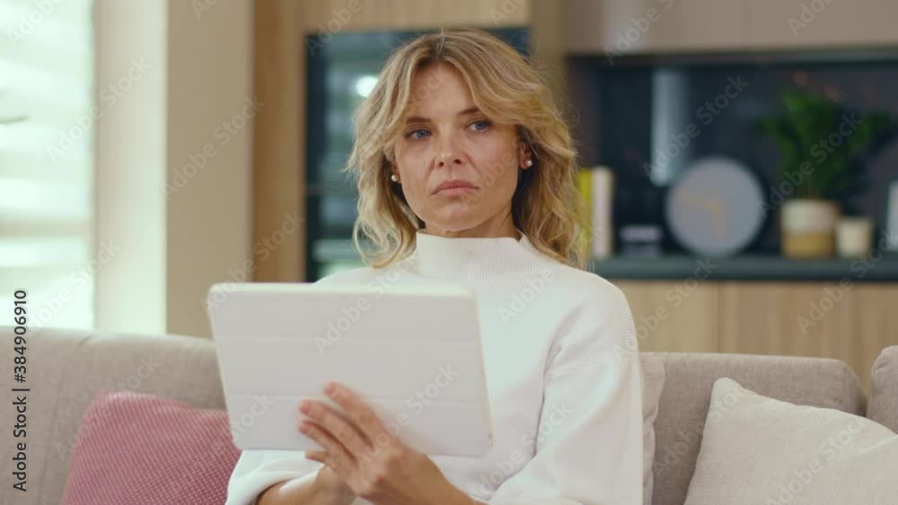 Close up young good looking woman using tablet device sitting on sofa at home. Girl mobile female table resting attractive beautiful. Slow motion Close up young good looking woman using tablet device sitting on sofa at home. Girl mobile female table resting attractive beautiful. Slow motion