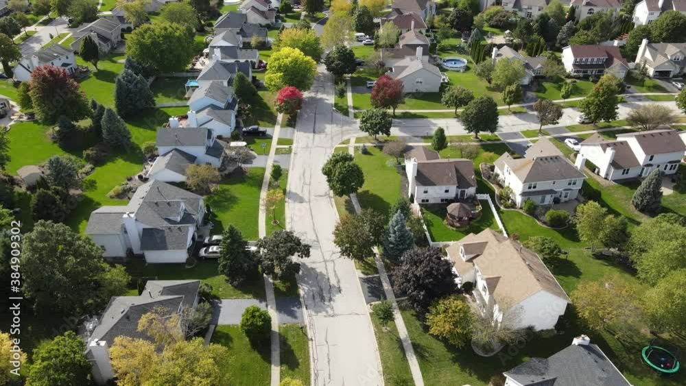 Overhead aerial view of colorful autumn trees, residential houses and yards along suburban street in Chicago area. Midwest USA
