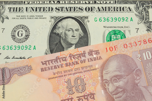 A macro image of a orange ten rupee bill from India paired up with a green one dollar bill from the United States.  Shot close up in macro.