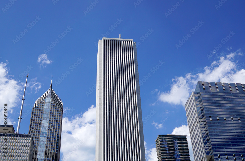 Downtown, Tall light building in the center. Blue sky with white clouds behind