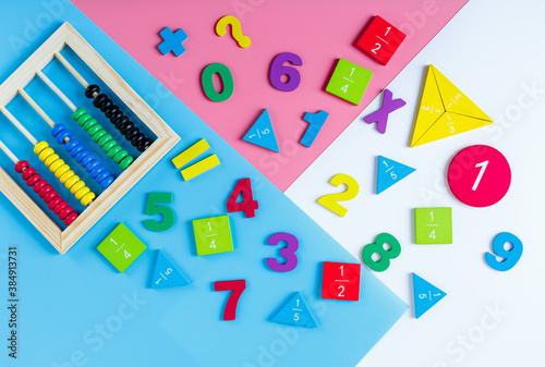 Colorful math fractions, numbers on blue pink white background. Interesting, fun mathematics for kids. Education, back to school concept