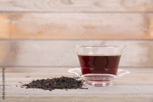 A bowl of brewed black tea drinks and a bunch of tea leaves