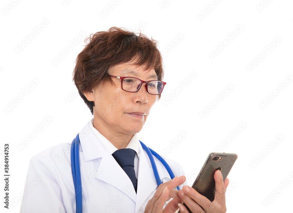 Chinese senior female doctor using mobile phone in front of white background Chinese senior female doctor using mobile phone in front of white background