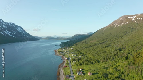 Aerial flyover of Rotsund, Norway along tranquil fjord and mountain landscape photo