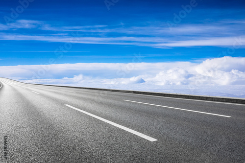 Empty asphalt road and blue sky with white clouds scenery. © ABCDstock