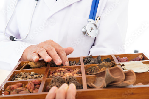 Close-up shot of a doctor holding a Chinese medicine box with his hand touching it