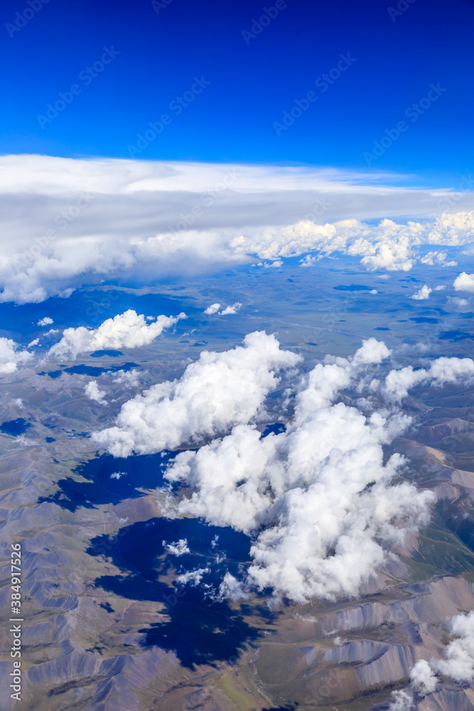 Aerial view above the clouds and mountain peaks on a sunny day. Aerial view above the clouds and mountain peaks on a sunny day.