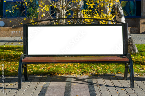 Empty Billboard with space for text, advertising on the street on a bench in the city in autumn