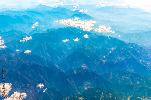 Aerial view above the clouds and mountain peaks on a sunny day.mountain view from airplane. © ABCDstock